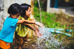 Kids palying in water. Powerful philanthropic practices.