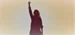 Woman in shadow raising her fist. Social justice.