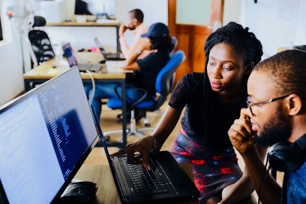 Woman teaching a man how to use computer. Resources for Experienced Activists.