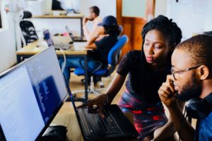Woman teaching a man how to use computer. Resources for Experienced Activists.