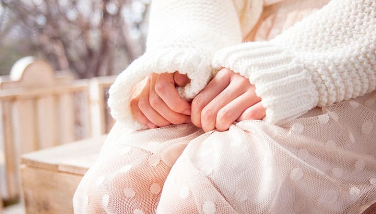 womans hands in white sweater