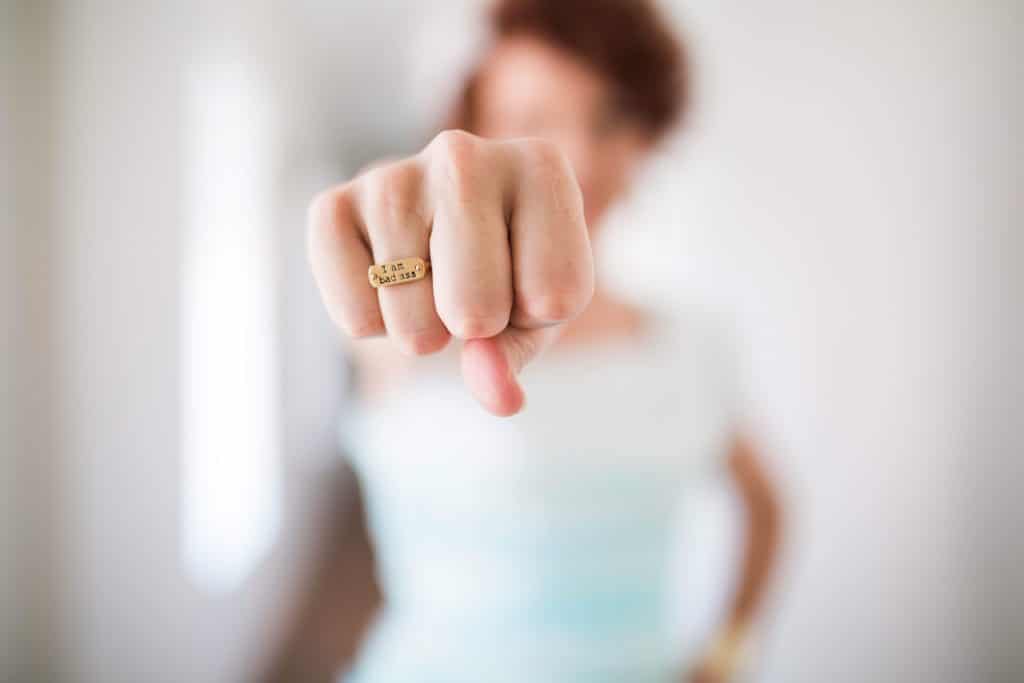 woman showing fist with I am Badass ring.