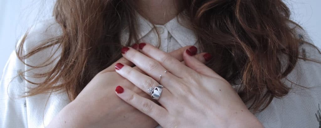 woman with hands crossed against her heart. Find your purpose and make a difference. Align your vales with action.