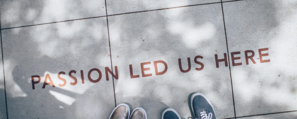 Passion led us here written on sidewalk. Stay motivated.