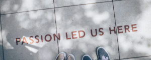 Passion led us here written on sidewalk. Stay motivated.