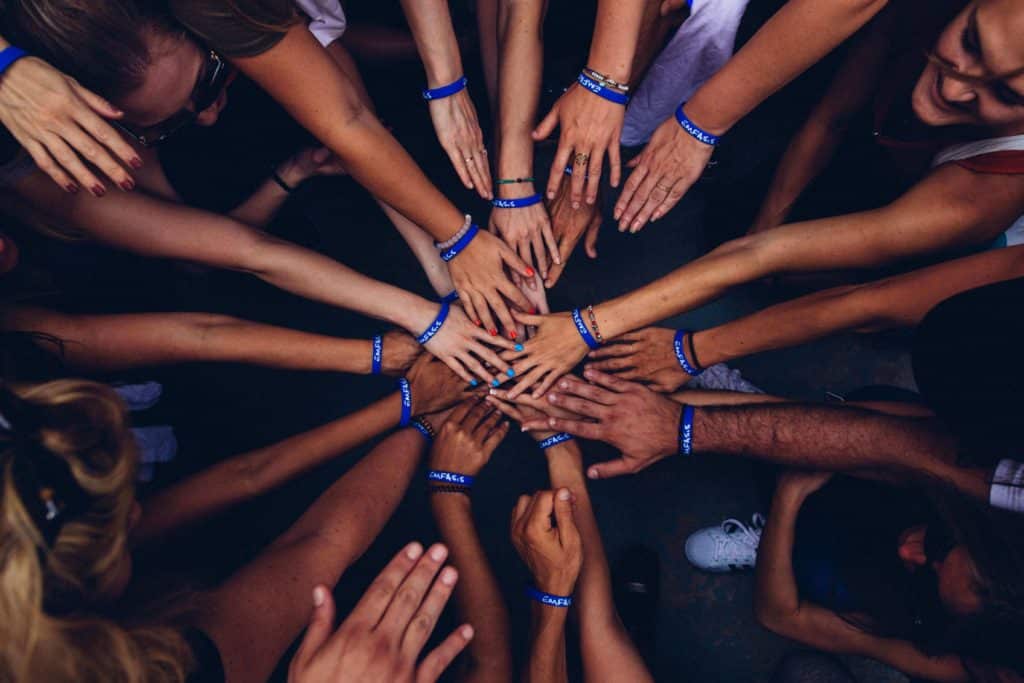 many hand reaching towards one another, symbolizing activism impact