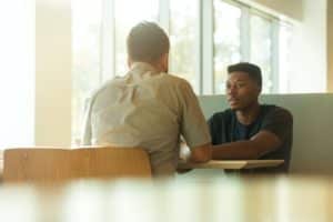 Two men talking in a booth