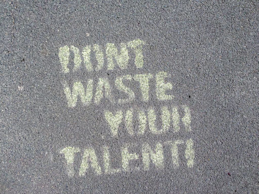 Sidewalk with chalk writing that says Don't Waste Your Talent. Use your talents