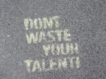 Sidewalk with chalk writing that says Don't Waste Your Talent. Use your talents