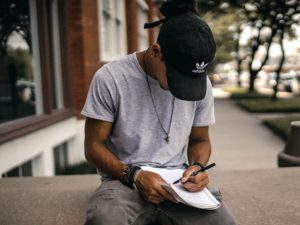 Man writing in journal how to