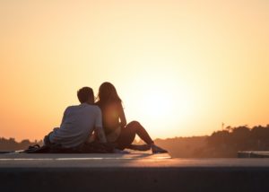 A seated couple from the back, watching a sunset