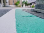 Teal and white path painted on asphalt action plan example
