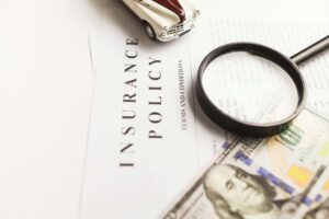 Desktop iwht insurance policy magnifying glass and a dollar bill. Mental health.