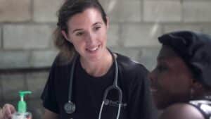 White woman with a stethoscope around her neck smiles at a black woman. Greater good post.