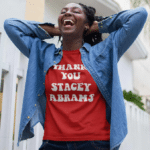 A woman wearing a red t-shirt with Thank You Stacy Abrams in white letters. Unique gifts for activists.