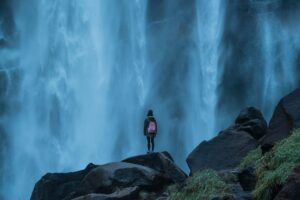 Woman in front of a raging waterfall. How to get involved in activism. Making a differences for your community.