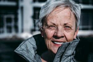 Older white woman with a large collar, smiling. How to get involved in activism. Making a difference in your community.