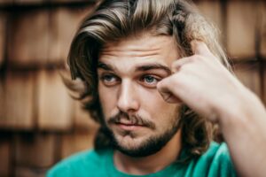 White man with brown hair and a beard, looking skeptical.