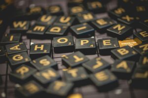 A pile of black Scrabble tiles forming the word "hope." Turn your passion into action.