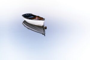 A boat on a clear, still lake. Rumi life Rumi quote brain health.