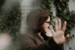A women turns her head away and puts her hand up to say no. The meaning of boycott. Buycotting.
