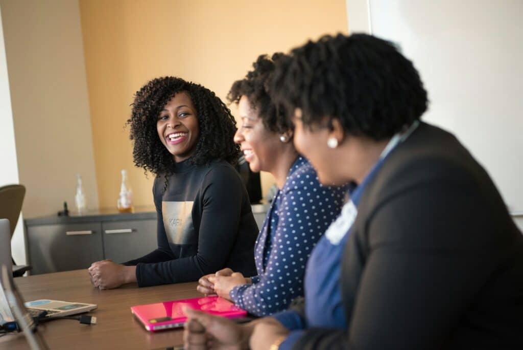 Three women leaders at a table using activist leadership resources.